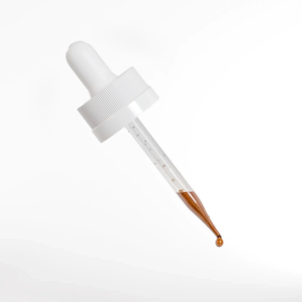Hair growth serum dropper with amber liquid, nourishing scalp for thicker-looking hair
