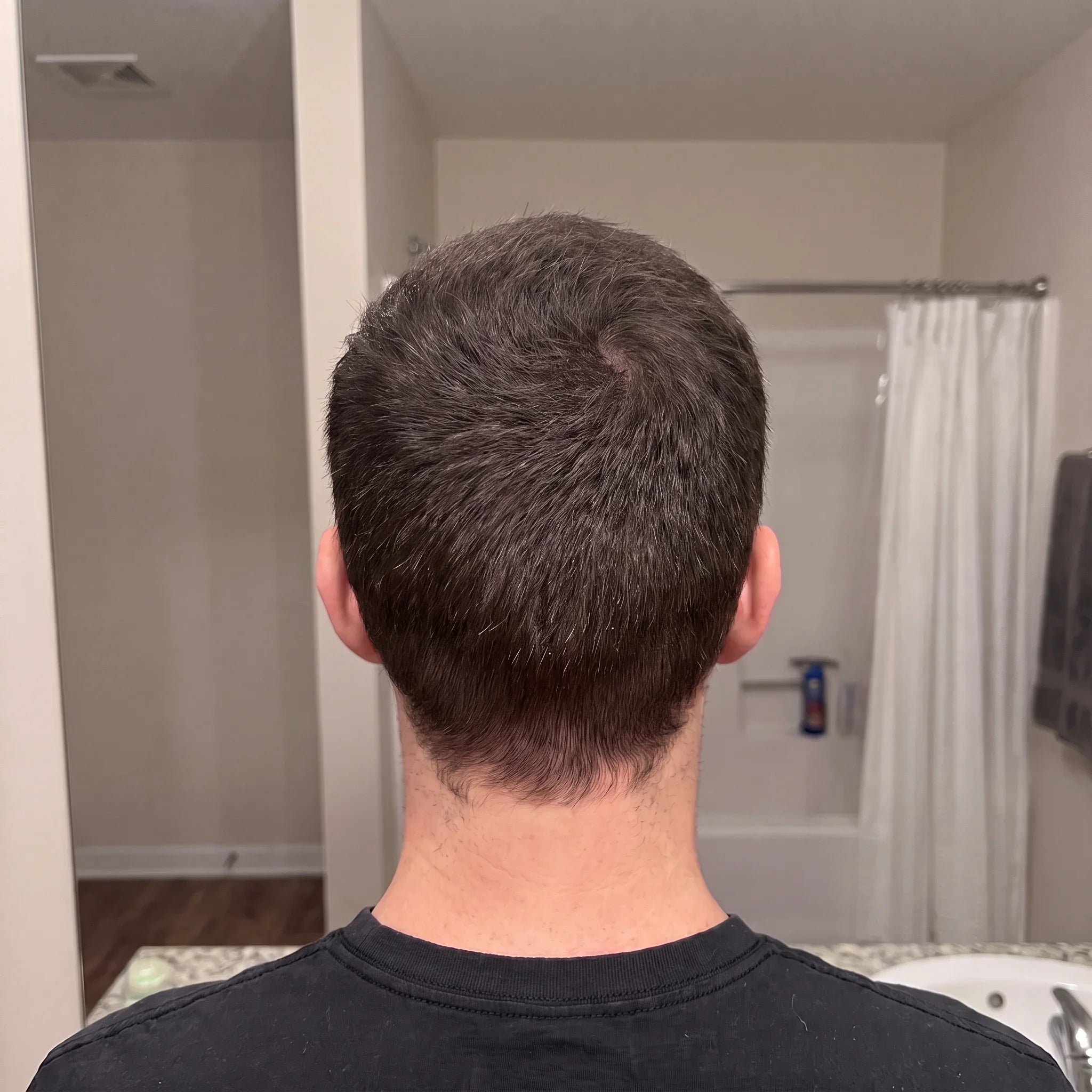 Back view of thick, healthy hair after using hair growth serum in bathroom setting